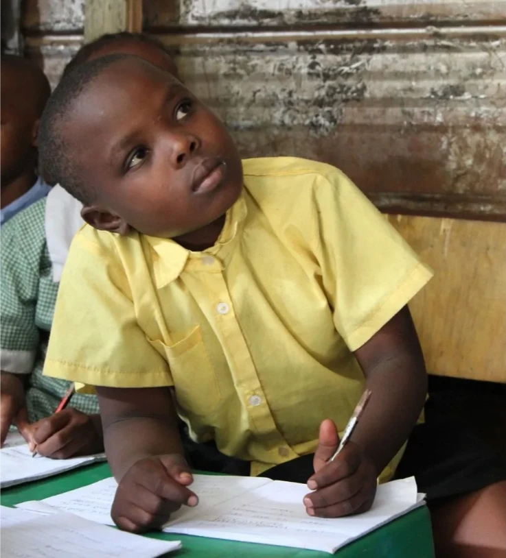 A boy writing in his exercise book at Rossholme School